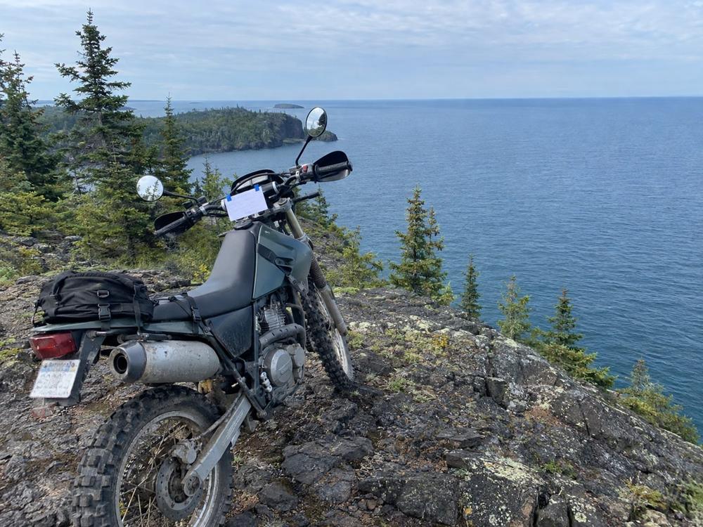 Dual-sport motorcycle on a rocky overlook above Lake Superior